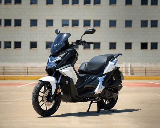 Pogled na parkiran belo-črn skuter Sixteen s prostornino motorja 125 ccm od spredaj in bočno
