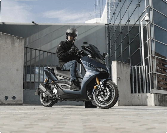 Siv skuter Storm-R CBS s prostornino motorja 125 ccm z moškim s čelado