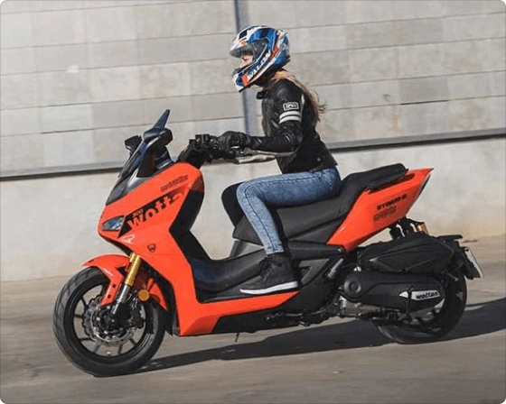 Rdeč skuter Storm-R CBS 300 ccm z dekletom med vožnjo